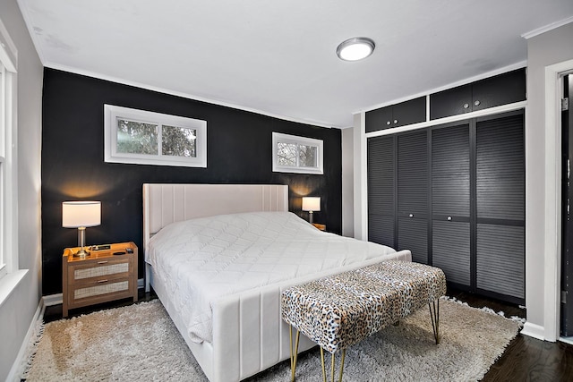 bedroom featuring crown molding, dark hardwood / wood-style floors, and a closet