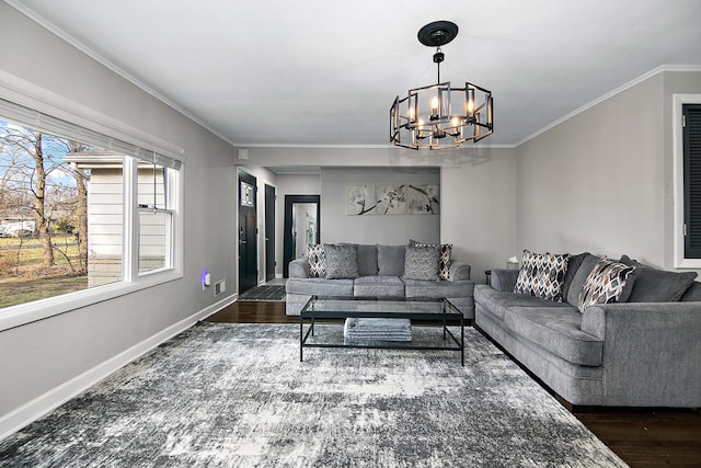 living room with ornamental molding, dark wood-type flooring, and an inviting chandelier