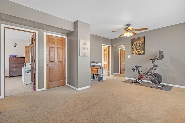 workout room with ceiling fan and light colored carpet