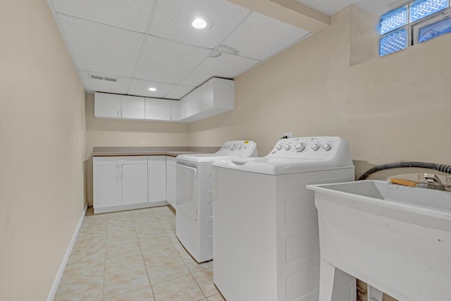 laundry room with cabinets, sink, washing machine and clothes dryer, and light tile patterned flooring