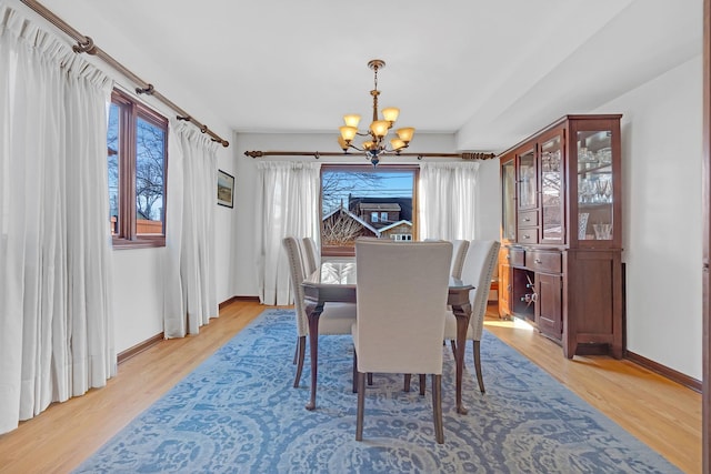 dining area featuring light wood-type flooring and an inviting chandelier