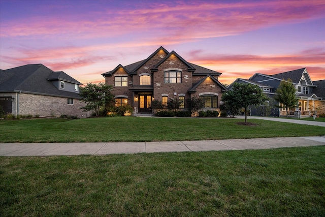 french country inspired facade featuring a yard