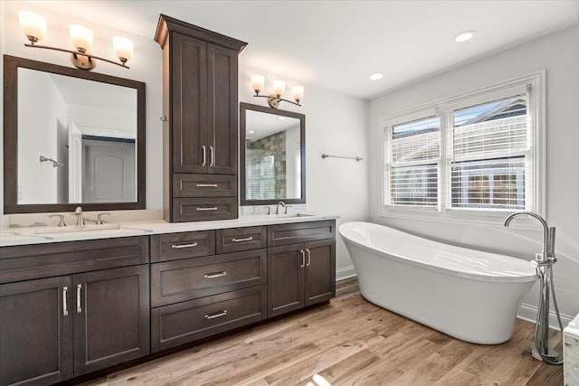 bathroom with a bathtub, wood-type flooring, and vanity