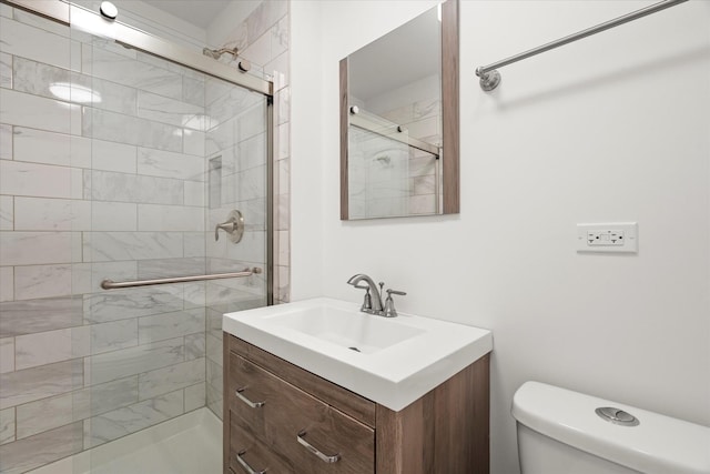 bathroom featuring vanity, toilet, and a shower with shower door