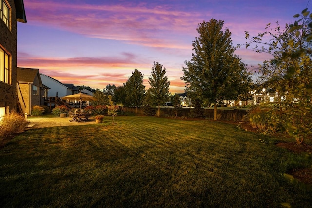 yard at dusk featuring a patio