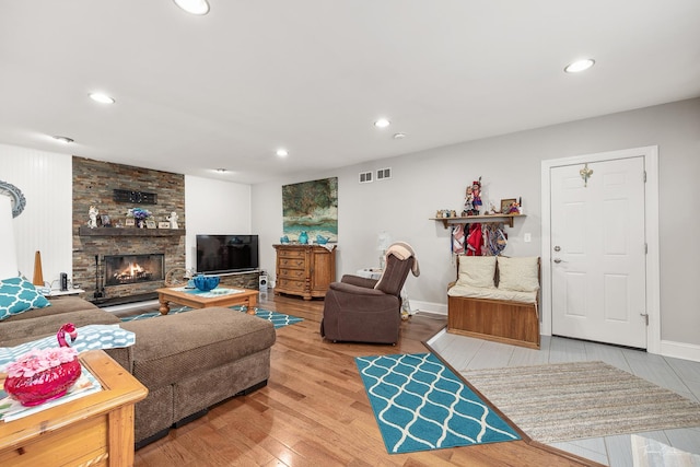 living room with a fireplace and wood-type flooring