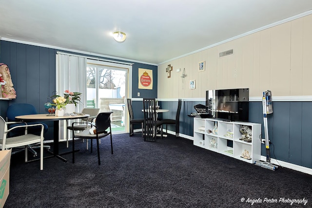 office with ornamental molding, wooden walls, and dark carpet