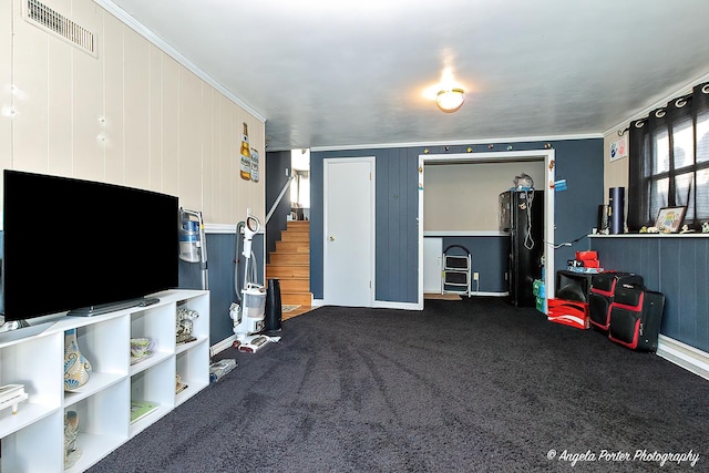 carpeted living room with wooden walls and ornamental molding