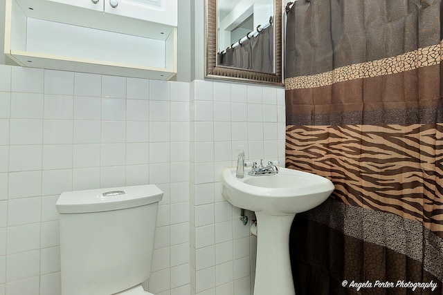 bathroom with tile walls, decorative backsplash, and toilet