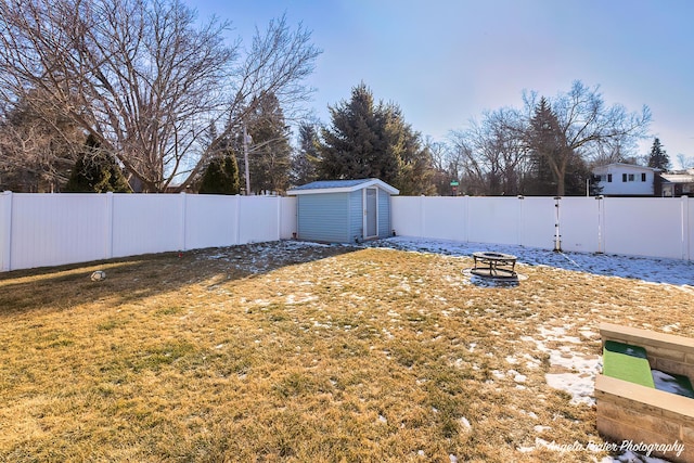 view of yard with a shed and an outdoor fire pit