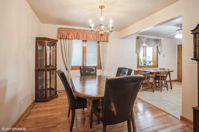 dining space featuring ceiling fan with notable chandelier and light wood-type flooring