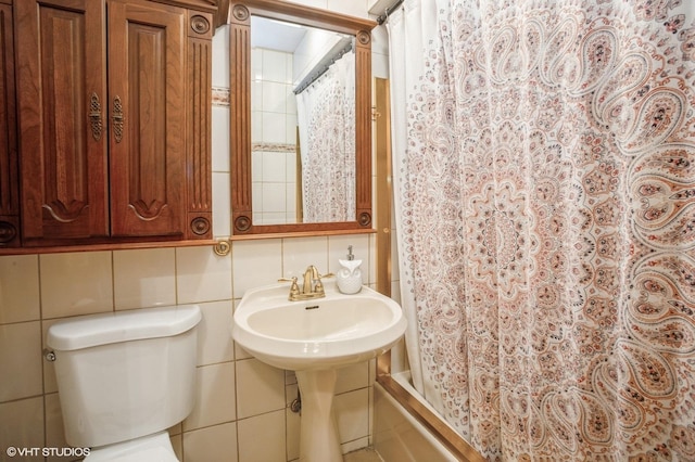 full bathroom with sink, shower / bathtub combination with curtain, toilet, decorative backsplash, and tile walls