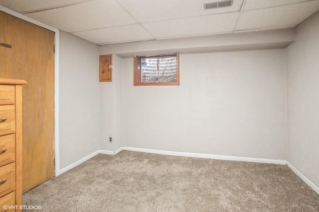 basement featuring a drop ceiling and carpet floors