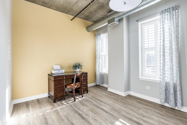 home office with light wood-type flooring and a wealth of natural light