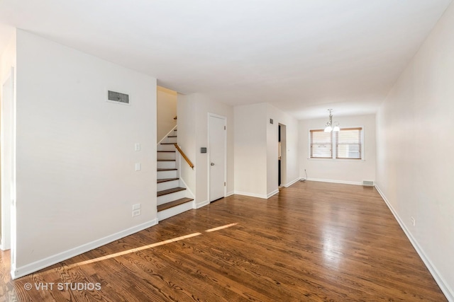 unfurnished living room with dark hardwood / wood-style flooring and a chandelier