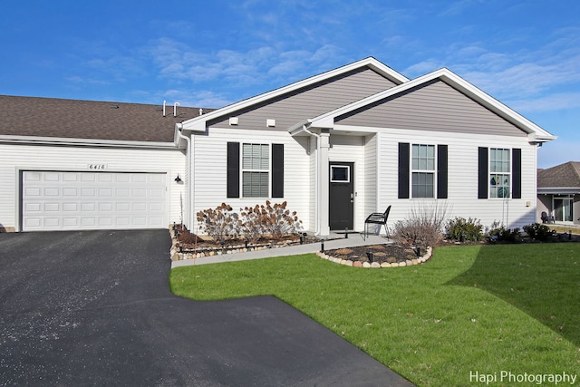 ranch-style house featuring a garage and a front lawn