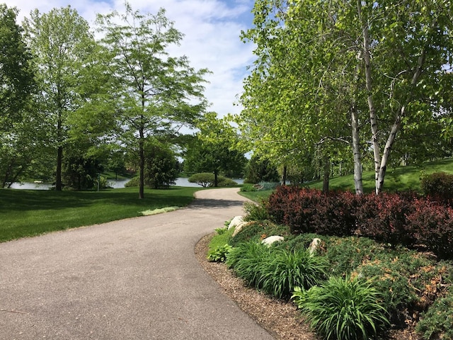 view of home's community featuring a lawn and a water view