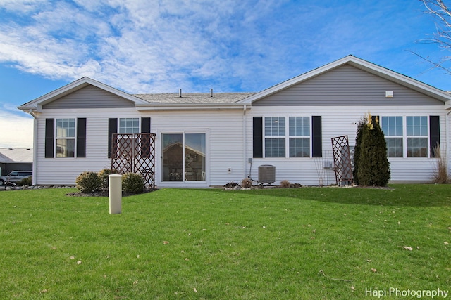 rear view of house with a lawn and central AC