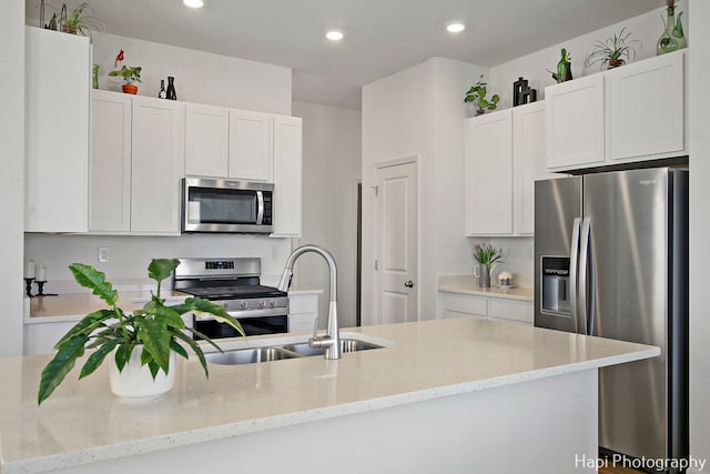 kitchen featuring light stone countertops, appliances with stainless steel finishes, and white cabinetry