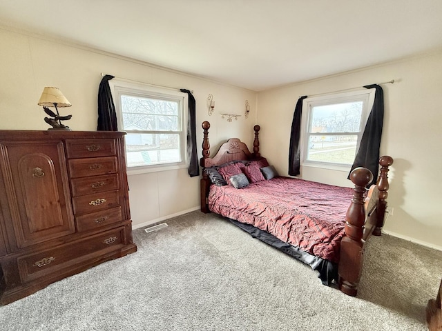 bedroom with multiple windows and light colored carpet