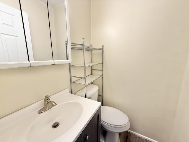 bathroom with vanity, toilet, and wood-type flooring