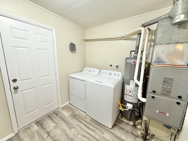 laundry area with heating unit, crown molding, water heater, washer and dryer, and light hardwood / wood-style floors