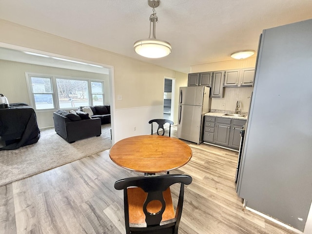 dining space featuring light hardwood / wood-style flooring and sink