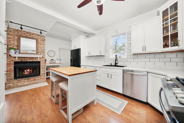 kitchen with white cabinetry, sink, backsplash, and stainless steel appliances