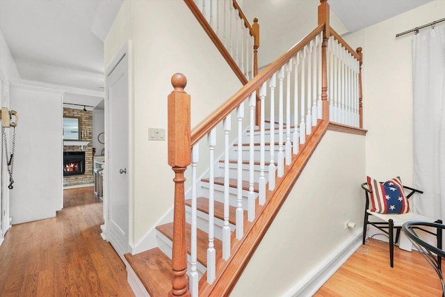 staircase featuring a fireplace and hardwood / wood-style floors