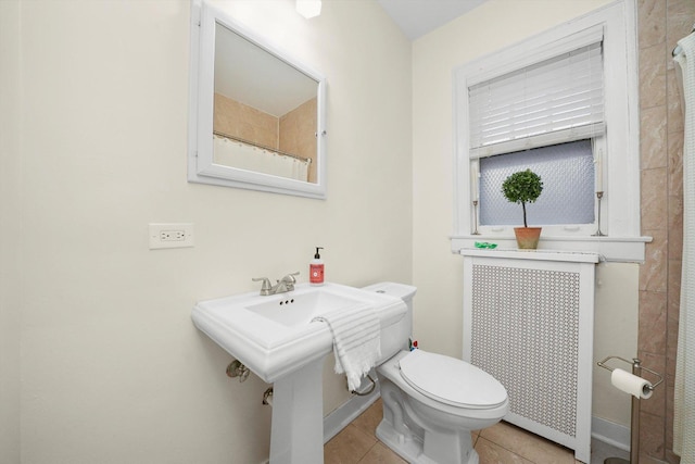 bathroom with curtained shower, tile patterned floors, toilet, and radiator