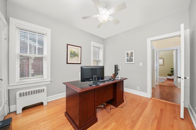 office space with radiator, ceiling fan, and light hardwood / wood-style flooring