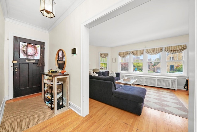 entryway featuring wood-type flooring, radiator, and crown molding