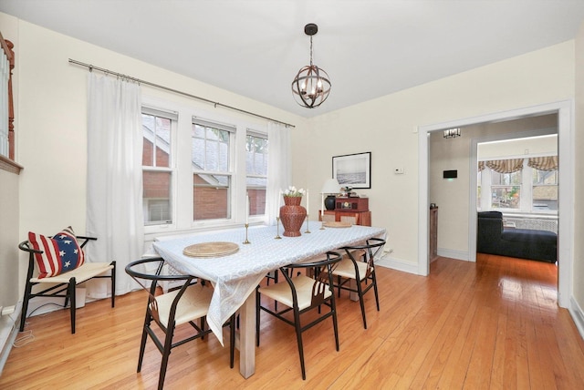 dining space featuring an inviting chandelier and light hardwood / wood-style flooring