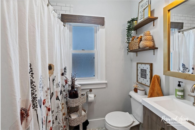 bathroom featuring walk in shower, vanity, and toilet