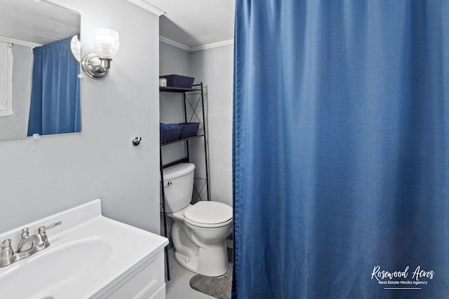 bathroom with toilet, vanity, and ornamental molding