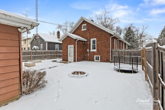 snow covered house featuring an outdoor fire pit