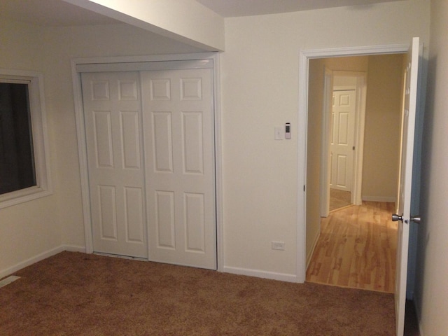 unfurnished bedroom with carpet and a closet