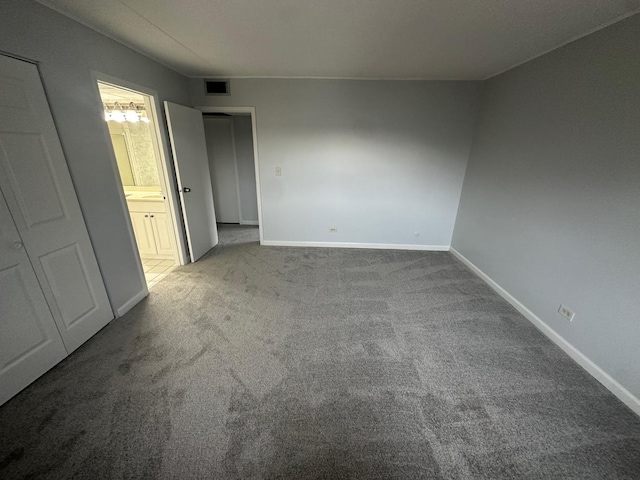 unfurnished bedroom with carpet floors and connected bathroom