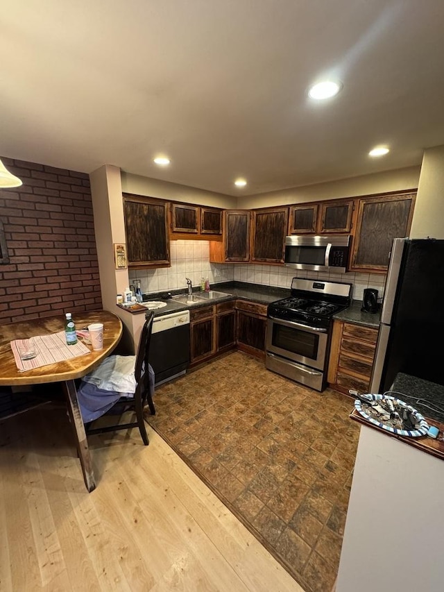 kitchen with backsplash, sink, light hardwood / wood-style flooring, appliances with stainless steel finishes, and dark brown cabinetry