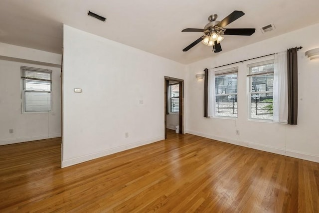 unfurnished room with light wood finished floors, a ceiling fan, and baseboards