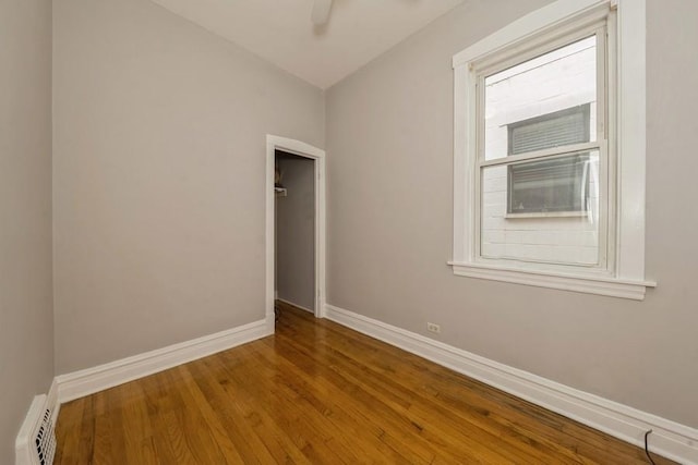 unfurnished room with wood finished floors, baseboards, and ceiling fan