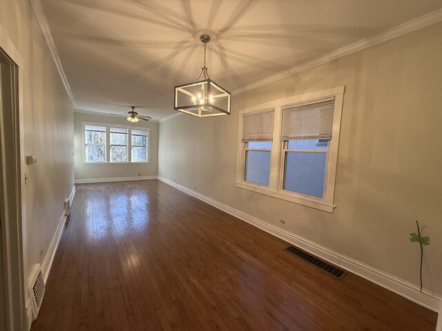 spare room with wood-type flooring, an inviting chandelier, and crown molding