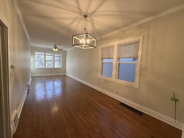 empty room with dark wood finished floors, visible vents, baseboards, and ornamental molding