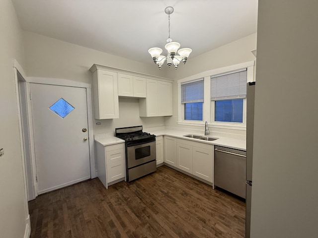 kitchen with a sink, dark wood-style floors, white cabinetry, stainless steel appliances, and light countertops