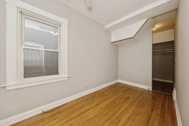 unfurnished bedroom with ceiling fan, wood-type flooring, and a closet