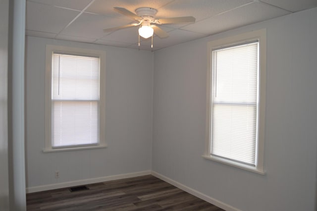 unfurnished room featuring dark wood-type flooring, a drop ceiling, and ceiling fan