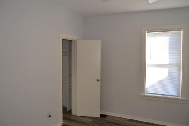 unfurnished bedroom featuring dark hardwood / wood-style flooring and a closet