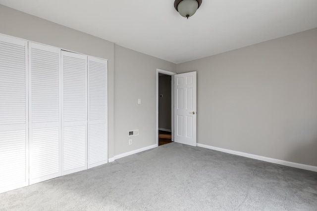 unfurnished bedroom featuring carpet flooring and a closet