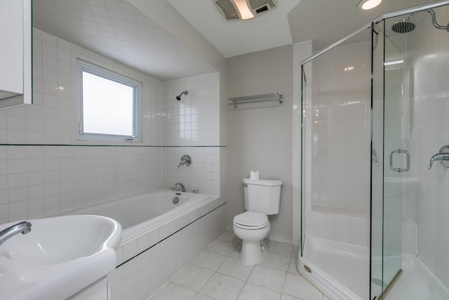 bathroom with tile patterned flooring, shower with separate bathtub, and toilet