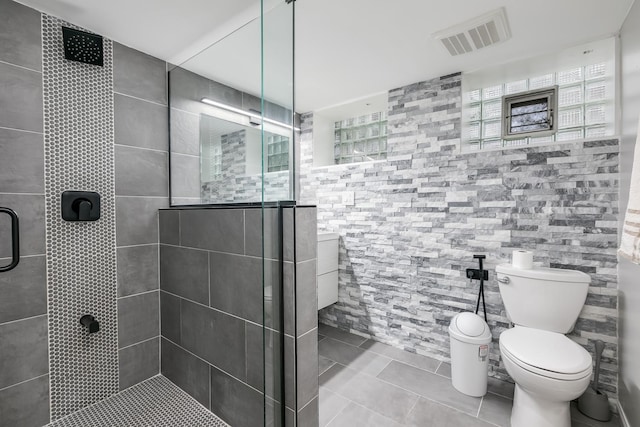 bathroom featuring toilet and a shower with door